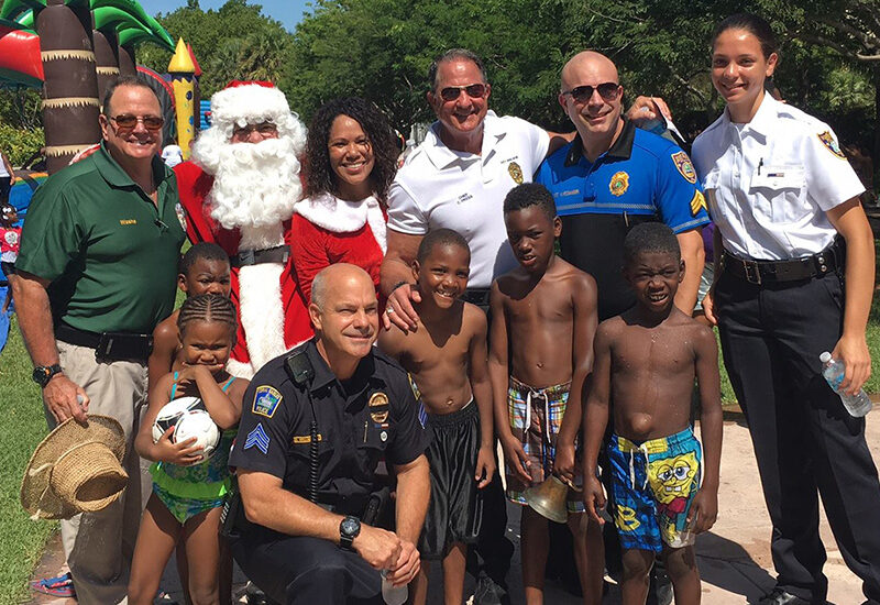 Children from Liberty City pose with Santa Claus and Chief Press in Key Biscayne.